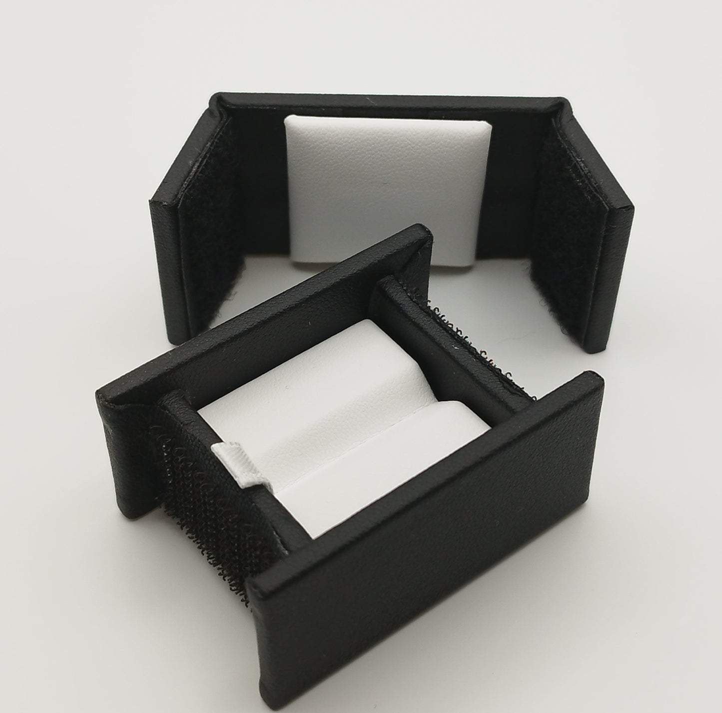 Rectangular leather-like black box with Velcro closure and white bifurcated pad (5,4 * 4 * 2,5 cm)